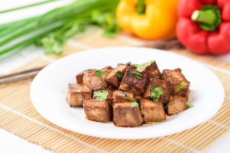Fried tofu with soy sauce on white plate, vegetarian foodの写真素材