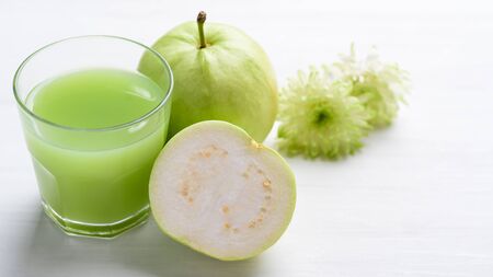 Green guava fruit and guava juice in glass on white background, high vitamin C healthy drinkの写真素材