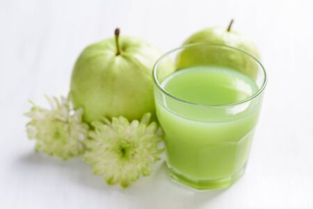 Green guava fruit and guava juice in glass on white background, high vitamin C healthy drinkの写真素材