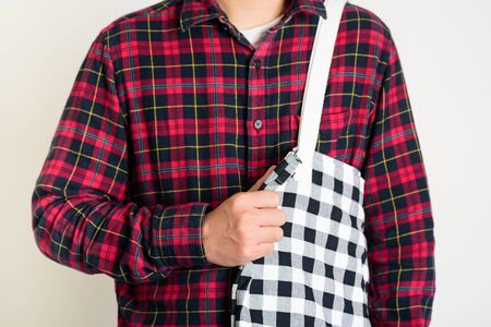 Young man holding fabric cotton tote bag, no plastic and reuse conceptsの写真素材