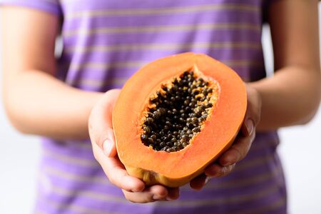 Half ripe papaya fruit holding by woman hand, Tropical fruitの写真素材
