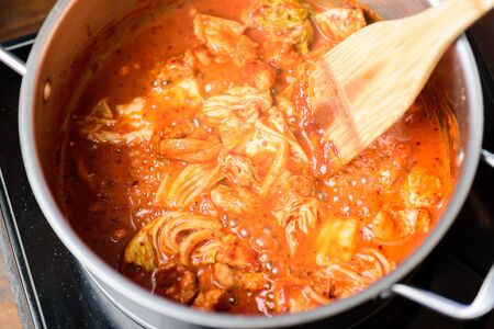 Kimchi soup with tofu cooking in hot pot, Korean food (Kimchi Jjigae)