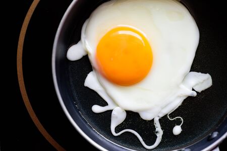 Fried egg cooking in hot pan, Top view