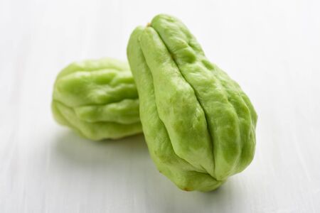 Chayote squash or Mirlition squash on white table, organic vegetable,  edible plant fruitの写真素材