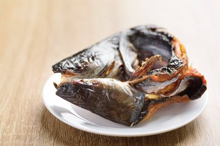 Roasted smoked pangasius fish on white dish preparing for cooking