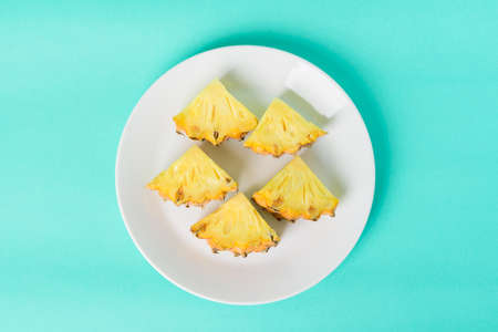 Sliced pineapple fruit on white plate with pastel green background, Tropical fruitの写真素材