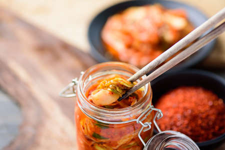 Korean food, kimchi cabbage in liter clamp jar eating with chopsticks