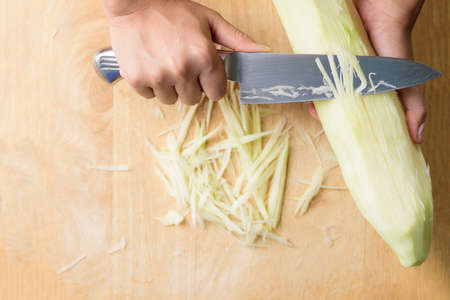 Hand holding knife and chopped green papaya fruit preparing for papaya salad cooking, Thai foodの写真素材