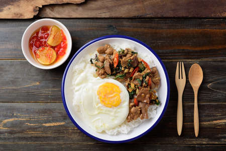 Thai food, Stir fried pork with basil and fried egg on cooked rice eating with chili in fish sauce (Pad Kaprao Moo Kai Dao)の写真素材