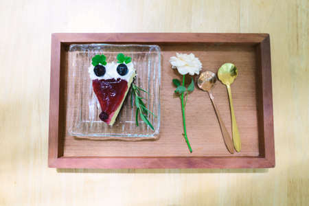 Sliced of blueberry cheesecake on wooden tray ready to eating in the cafeの写真素材