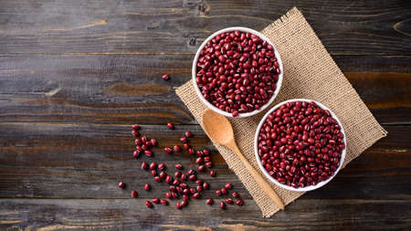 Azuki beans or red mung beans in a bowl and spoon on wooden table, Top viewの写真素材