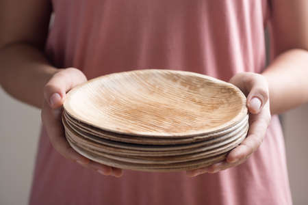 Hand holding Betel palm leaf plate (Biodegradable, Compostable or Eco friendly disposable plate), sustainable conceptの写真素材