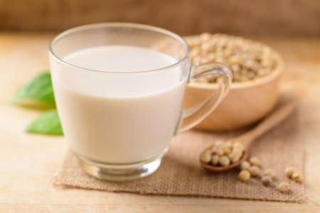 Soy milk in the glass and soy beans on wooden background, Healthy drinkの写真素材