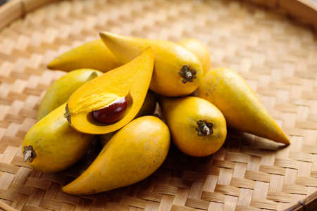 Eggfruit or canistel on bamboo tray, Thai fruit, In Thai names such as Xiantao, Lamut Khamen or Mon khaiの写真素材