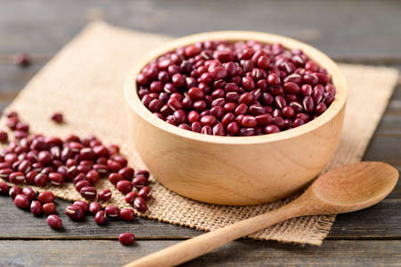 Azuki beans or red mung beans in a bowl and spoon on wooden tableの写真素材