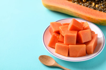 Sliced ripe papaya fruit on plate with spoon on pastel color background, Tropical fruitの写真素材