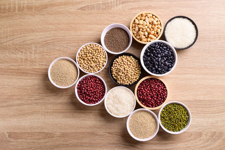 Various cereal grain in a bowl on wooden background (quinoa seeds, black kidney bean, peanut,...