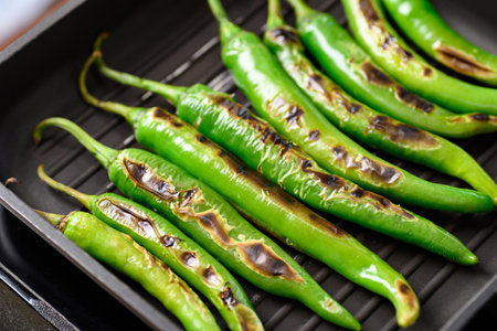 Grilled green chili pepper on grill pan preparing for Northern Thai food (Nam Prik Num)の写真素材