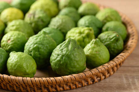 Fresh bergamot fruit in a basket on wooden table, Food ingredients and extract used for medicine, tea, perfumes and cosmeticsの写真素材