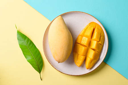 Ripe and  sliced cube mango fruit with leaf on color background, Tropical fruitの写真素材