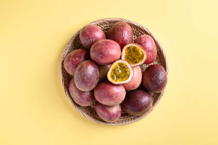 Fresh passion fruit in a basket on yellow backgroundの写真素材
