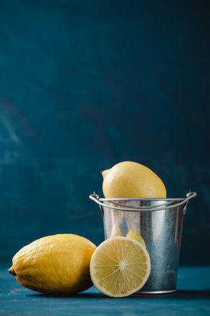 Fresh lemon with bucket on dark green color backgroundの写真素材