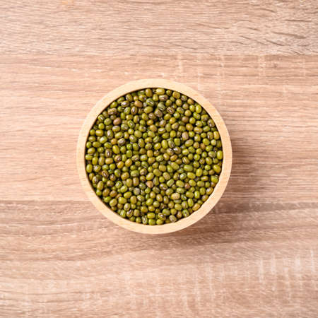 Mung bean seeds in a bowl on wooden background, Food ingredients in Asian cuisine and produce mung...