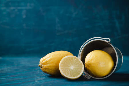 Fresh lemon with bucket on dark green color backgroundの写真素材
