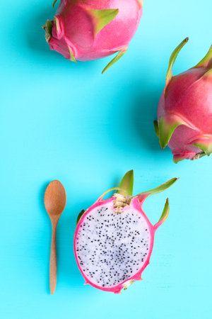 Half dragon fruit or pitaya and wooden spoon for eating on color background, Tropical fruitの写真素材