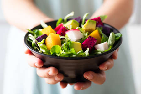 Healthy vegan salad fruits and vegetables with avocado, dragon fruit, radish, pumpkin and corn salad...