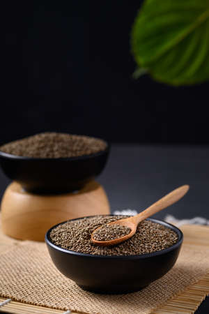 Perilla seeds in a black bowl with spoon, Healthy herbal seed ingredients in Asian food, Still Lifeの写真素材