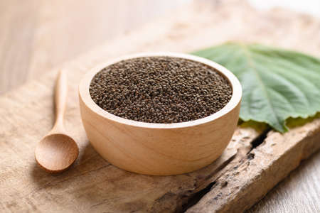 Perilla seeds in a bowl with spoon on wooden background, Healthy herbal seed ingredients in Asian foodの写真素材