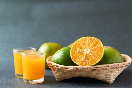 Fresh green tangerine fruit in bamboo basket and juice, Healthy drinkの写真素材