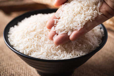 Close up of Organic Thai Jasmine rice grain in a black bowl with handの写真素材