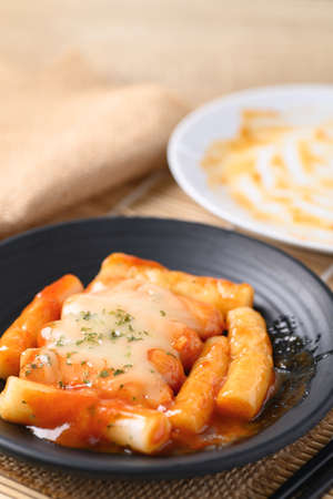 Korean food, Tteokbokki (sliced rice cakes) or tokpokki and sausage with cheese in spicy sauce
