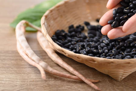 Black kidney beans in a bamboo basket with handの写真素材