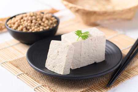 Sliced fresh tofu on black plate, Vegan Food ingredients in Asian foodの写真素材