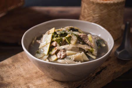 Northeastern Thai food, Spicy bamboo shoot soup with pork and vegetables eating with sticky rice,...