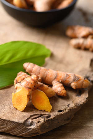 Fresh turmeric on wooden background, Food ingredients in Asian food and used in beauty spa and herbal medicineの写真素材