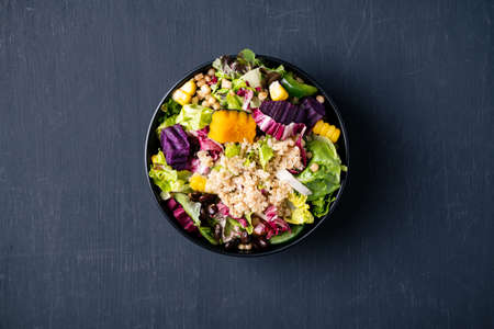 Fresh organic vegetables salad with quinoa seed in bowl on black background, Healthy Vegan food, Top viewの写真素材