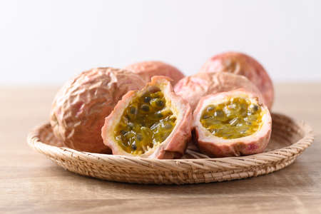 Overripe passion fruit in basket on wooden table
