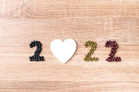 2022 new year made from bean seed (black soybean, mung bean and azuki bean) with white heart shape...