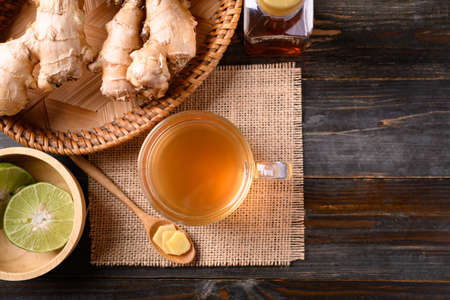 Ginger tea with lime and honey on wooden background, Healthy herbal drink, Table top view