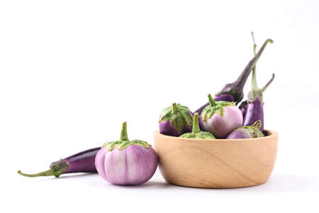 Fresh organic Thai purple eggplant in wooden bowl on white background, Food ingredientの写真素材