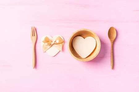 Fork and spoon with heart shape on pink background, Valentine day concept
