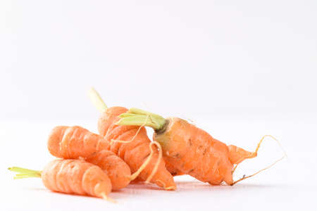 Organic carrots on white background, imperfectly shapeの写真素材