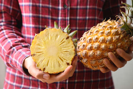 Fresh pineapple fruit holding by hand, Tropical fruit