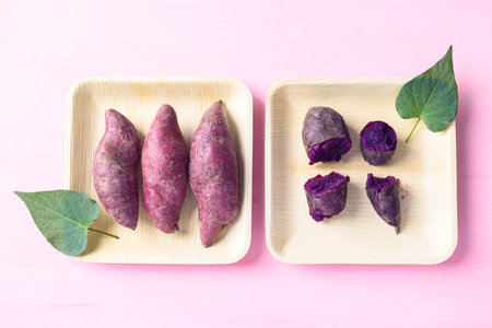 Purple sweet potatoes on natural plate with pink background, Top viewの写真素材