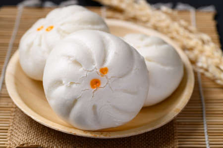 Steamed Chinese bun stuffed with minced pork, egg yolk or sweet on natural plate, Asian food