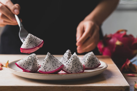 Hand holding fork and eating dragon fruit or pitaya, Tropical fruitの写真素材